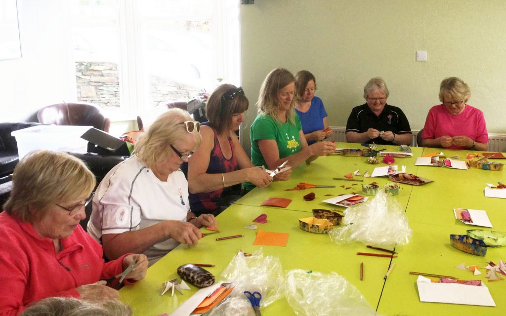 Shelley and Neecol Barlow help us learn to make garlands for Florence for the Team Pink Procession.